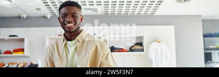 portrait de jeune afro-américain propriétaire d'un studio d'impression souriant à la caméra, bannière horizontale Banque D'Images