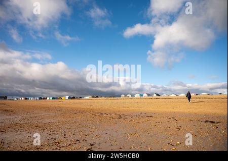 Huttes de plage de Hayling Island dans l'image du paysage en hiver avec marcheur Banque D'Images