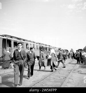 Passagers et traînards à une gare dans le Moyen-Orient ca. 1950-1955 Banque D'Images