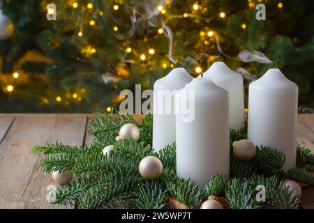 Couronne de l'Avent avec quatre bougies blanches, branches de sapin sur fond en bois. Dimanche décembre. Décoration traditionnelle de Noël diy, fond de vacances. Banque D'Images