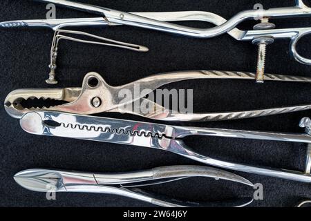 Le détail des instruments chirurgicaux antiques en métal brillant disposés ensemble Banque D'Images