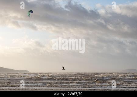 Weston super Mare, Royaume-Uni. Un Kitesurfer ou Kiteboarder profite des vents forts pendant la tempête Pia pour faire un saut en hauteur au-dessus des vagues de la mer Banque D'Images