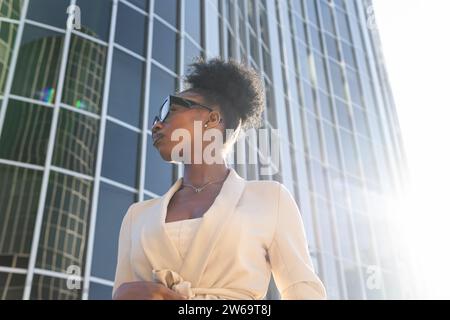 Angle bas de élégant Noir jeune femme Manager portant des lunettes et des formals contre le bâtiment dans la ville Banque D'Images
