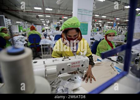 Le 21 décembre 2023, un travailleur du prêt-à-porter travaille dans une usine de vêtements à Dhaka, au Bangladesh. Les usines textiles bangladaises ont une production de cl Banque D'Images