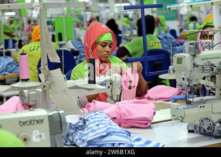 Le 21 décembre 2023, un travailleur du prêt-à-porter travaille dans une usine de vêtements à Dhaka, au Bangladesh. Les usines textiles bangladaises ont une production de cl Banque D'Images