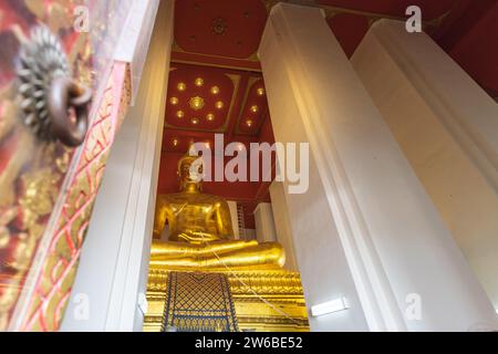 D'en bas de la grande statue de bouddha dorée méditation à l'intérieur de Wihan Phra Mongkhon Bophit à Ayutthaya, Thaïlande Banque D'Images