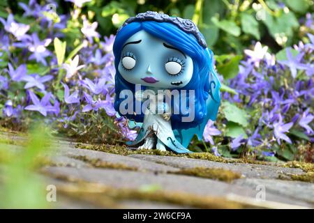 Funko Pop figure d'action d'Emily du film d'animation gothique sombre de fantaisie Corpse bride. Fleurs bleues, mousse, route de pierre, jardin mystérieux, mariage. Banque D'Images