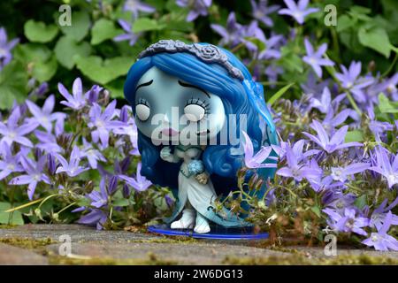 Funko Pop figure d'action d'Emily du film d'animation gothique sombre de fantaisie Corpse bride. Fleurs bleues, mousse, route de pierre, jardin mystérieux, mariage. Banque D'Images