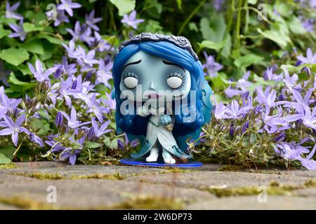 Funko Pop figure d'action d'Emily du film d'animation gothique sombre de fantaisie Corpse bride. Fleurs bleues, mousse, route de pierre, jardin mystérieux, mariage. Banque D'Images