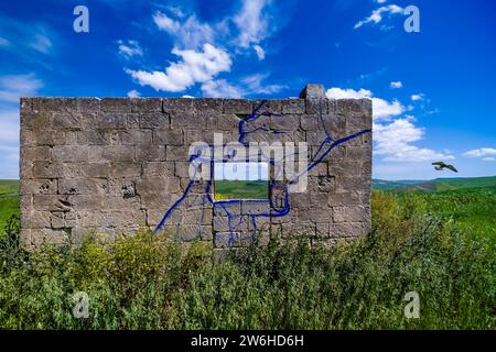 Graffiti d'une vue de photographes peint sur un mur d'une maison de fermiers en ruine dans le paysage agricole de Basilikata. Banque D'Images