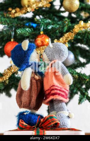 Chat et ours en peluche tricotés auto-tricotés sous le sapin de Noël joliment décoré Banque D'Images