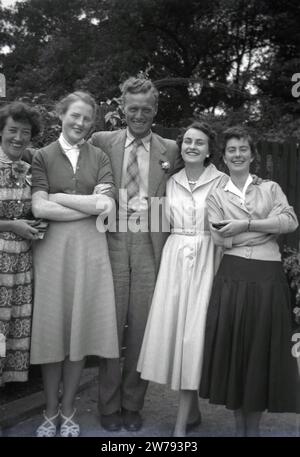 Années 1950, histoire, famille heureuse, une mère et un père se tiennent pour une photo avec leurs filles, Angleterre, Royaume-Uni. Les trois jeunes femmes portent les jupes élégantes et les hauts féminins stylistes de l'époque, Banque D'Images