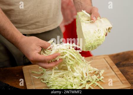 Préparation du chou blanc sur une planche de bambou, détail du processus de cuisson. Banque D'Images