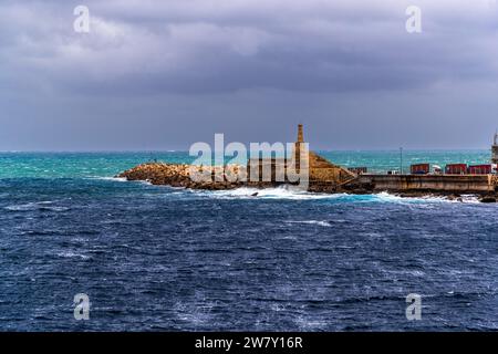 La traversée du ferry de Gozo Channel Line depuis Gozo se termine au brise-lames du terminal de ferry de Ċirkewwa près de Mellieħa sur l'île de Malte ; une structure en forme de tour marque l'entrée du port. Banque D'Images