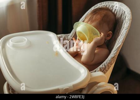 Un petit enfant mange de la purée de légumes sans cuillère. Banque D'Images