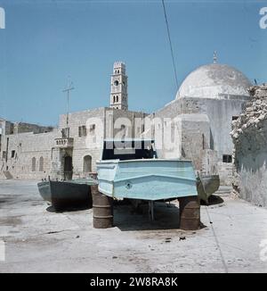 Acre (acre). Front de port avec une perceuse sur des barils d'essence rouillés sur le quai et au-dessus des maisons la tour du caravansérail-avec-les-colonnes et sur la droite un dôme d'une mosquée ca. 1964 Banque D'Images