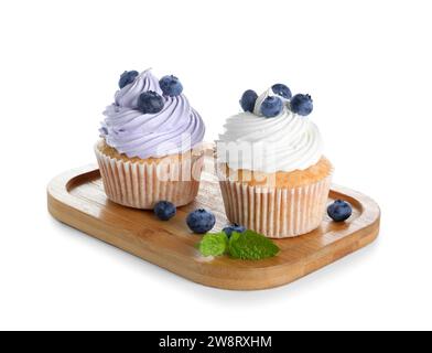 Planche en bois de délicieux cupcakes avec des myrtilles sur fond blanc Banque D'Images