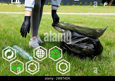 Femme avec sac poubelle ramassant les ordures dans la nature, closeup. Recyclage et autres icônes près d'elle Banque D'Images