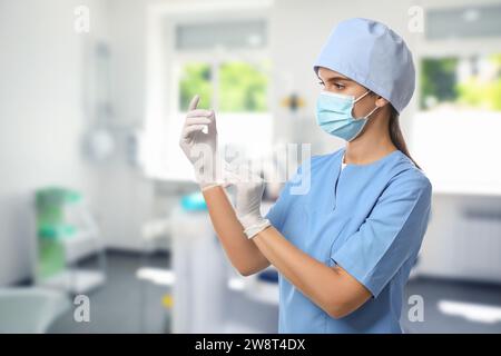 Infirmière en uniforme portant des gants à l'hôpital Banque D'Images