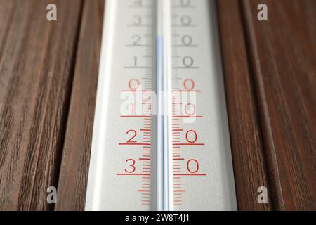 Thermomètre météo moderne sur fond en bois, gros plan Banque D'Images