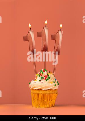 Gâteau d'anniversaire avec bougie numéro 111 - fond fusion corail Banque D'Images