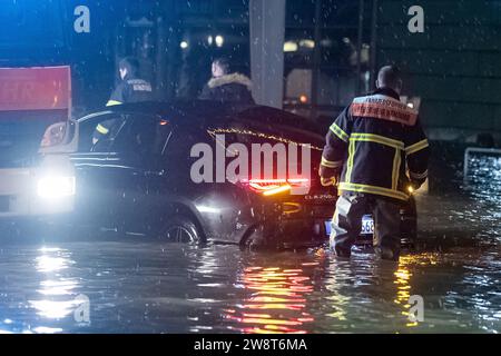 Hambourg, Allemagne. 22 décembre 2023. Une voiture est coincée dans l'eau de l'Elbe lors d'une onde de tempête près du marché aux poissons. Les pompiers fournissent une assistance. L'Agence fédérale maritime et hydrographique a prédit une onde de tempête sévère à Hambourg pendant la nuit en raison de la dépression de tempête 'Zoltant'. Crédit : Bodo Marks/dpa/Alamy Live News Banque D'Images