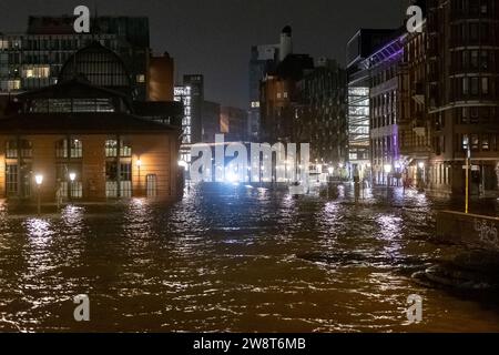 Hambourg, Allemagne. 22 décembre 2023. L'eau de l'Elbe est poussée sur le marché aux poissons lors d'une onde de tempête. L'Agence fédérale maritime et hydrographique a prédit une onde de tempête sévère à Hambourg pendant la nuit en raison de la dépression de tempête 'Zoltant'. Crédit : Bodo Marks/dpa/Alamy Live News Banque D'Images