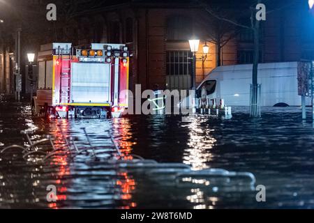 Hambourg, Allemagne. 22 décembre 2023. Une camionnette est debout dans l'eau de l'Elbe pendant une onde de tempête près du marché aux poissons. Les services d'urgence vérifient le véhicule pour voir s'il y a des personnes à l'intérieur. L'Agence fédérale maritime et hydrographique a prédit une onde de tempête sévère à Hambourg pendant la nuit en raison de la dépression de tempête 'Zoltant'. Crédit : Bodo Marks/dpa/Alamy Live News Banque D'Images