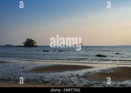 Pendant que le navire trouve du repos dans la baie, le remorqueur livre le charbon au port le plus proche. Banque D'Images