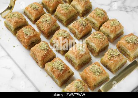 Délicieux baklava frais avec des noix hachées sur la table en marbre blanc, gros plan. Bonbons orientaux Banque D'Images