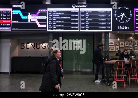 Londres, Royaume-Uni. 21 décembre 2023. Un membre du personnel Eurostar passe devant un panneau d'information affichant les services annulés. Les perturbations dans les transports se poursuivent au terminal Eurostar de St Pancras, où une grève antérieure a duré de midi jusqu'en début de soirée, lorsque des travailleurs français ont organisé une sortie inattendue, entraînant l'annulation de dizaines de trains. Les services ne devraient pas reprendre avant vendredi, affectant des milliers de passagers. Crédit : Photographie de onzième heure / Alamy Live News Banque D'Images