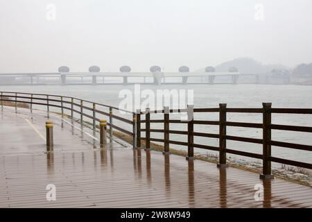 Comté de Yangpyeong, Corée du Sud - 16 février 2020 : une vue brumeuse et pluvieuse de IPO Weir et du fleuve Han Sud depuis une piste cyclable, mettant en valeur le mélange d'engi Banque D'Images