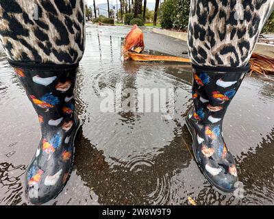 Santa Barbara, Californie, États-Unis. 21 décembre 2023. Une personne portant des bottes de pluie sur le thème du poulet et des pantalons extensibles guépards marche dans une rue lors d'un jour pluvieux, Solstace d'hiver à Santa Barbara. (Image de crédit : © Amy Katz/ZUMA Press Wire) USAGE ÉDITORIAL SEULEMENT! Non destiné à UN USAGE commercial ! Banque D'Images