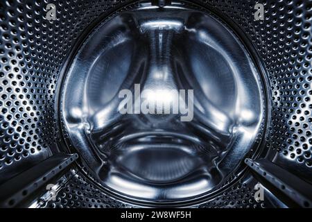 Lave-linge sèche-linge vue de l'intérieur. Tambour de lave-linge, vue de l'intérieur. Tambour métallique d'une machine à laver. Fond abstrait de la maison. À l'intérieur de Banque D'Images