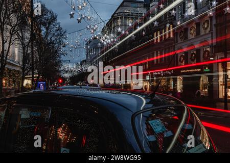 Traînées de lumière au crépuscule sur Oxford Street à Londres pendant la période des fêtes. Banque D'Images