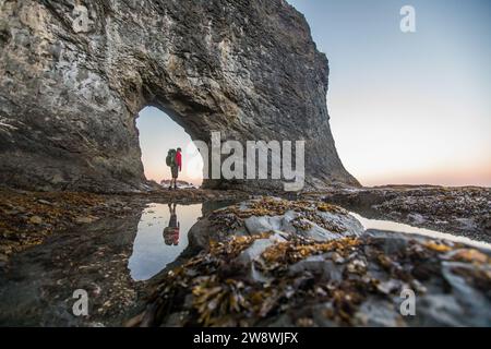 Angle bas de Backpacker debout à Hole-in-the-Wall, Rialto Beach Banque D'Images