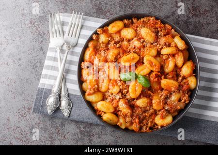 Délicieux gnocchi bolognais maison gros plan sur l'assiette sur la table. Vue de dessus horizontale Banque D'Images