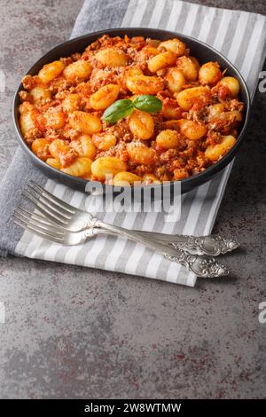 Cuisine italienne traditionnelle gnocchi de pommes de terre avec sauce bolognaise à la viande et parmesan closeup sur l'assiette sur la table. Vertical Banque D'Images