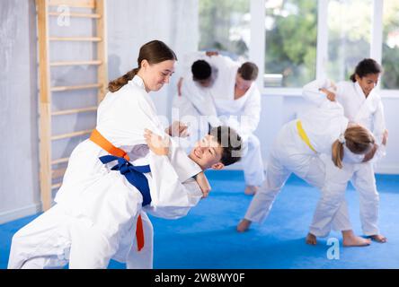 Adolescente pratiquant des techniques de combat pendant les arts martiaux sparring avec le garçon Banque D'Images