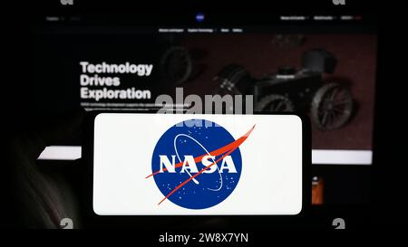 Personne tenant un smartphone avec le logo de la National Aeronautics and Space Administration (NASA) des États-Unis devant le site Web. Concentrez-vous sur l'affichage du téléphone. Banque D'Images