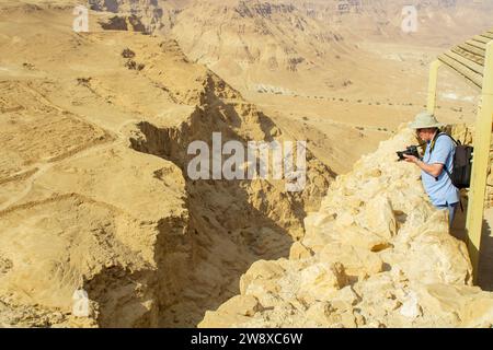 Novembre 2022, ATouriste photographiant la nature sauvage de Judée dans le sud d'Israël depuis le point de vue de Masada. Construit par Hérode le Grand, et l'anc Banque D'Images