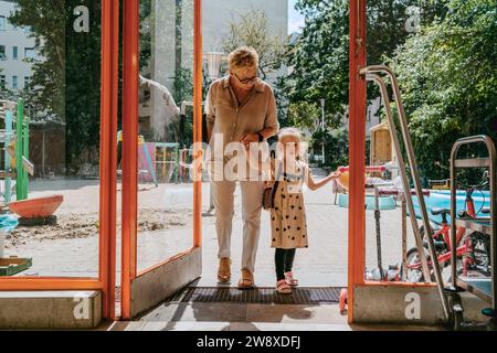Petite-fille avec grand-mère arrivant à la maternelle Banque D'Images