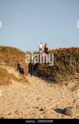 Homme et femme courant ensemble sur le sable à la plage contre le ciel Banque D'Images