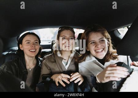Amis féminins excités voyageant en voiture en vacances Banque D'Images