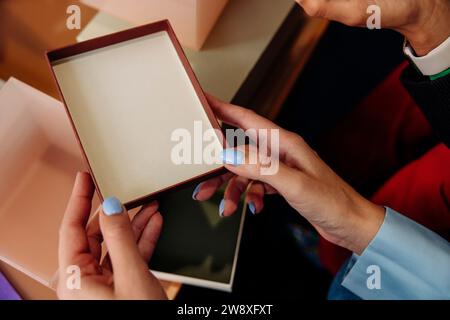 Vue à grand angle de la femme d'affaires tenant le couvercle de boîte au bureau Banque D'Images