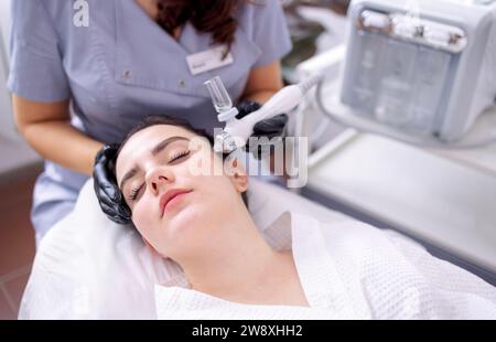 Femme caucasienne obtenant la procédure de peeling du visage dans une clinique de beauté, gros plan. Soin liquide au gaz du visage rajeunissant. Opération de nettoyage de la peau Hydro air Banque D'Images