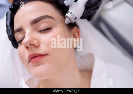 Femme caucasienne obtenant la procédure de peeling du visage dans une clinique de beauté, gros plan. Soin liquide au gaz du visage rajeunissant. Opération de nettoyage de la peau Hydro air Banque D'Images