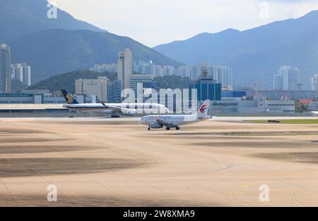 Airbus A350-900 de Singapore Airlines et Airbus A319 de China Eastern Airlines opéraient à l'aéroport international de Hong Kong. Banque D'Images
