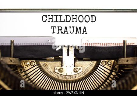 Symbole de traumatisme infantile. Mots conceptuels traumatisme de l'enfance tapé sur la belle vieille machine à écrire rétro. Beau fond de papier blanc. Psychologie des affaires Banque D'Images