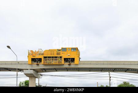 Les rails jaunes modernes maintenant la voiture de machine se tiennent par pour faire l'entretien le rail du système de monorail, Bangkok Thaïlande. Banque D'Images